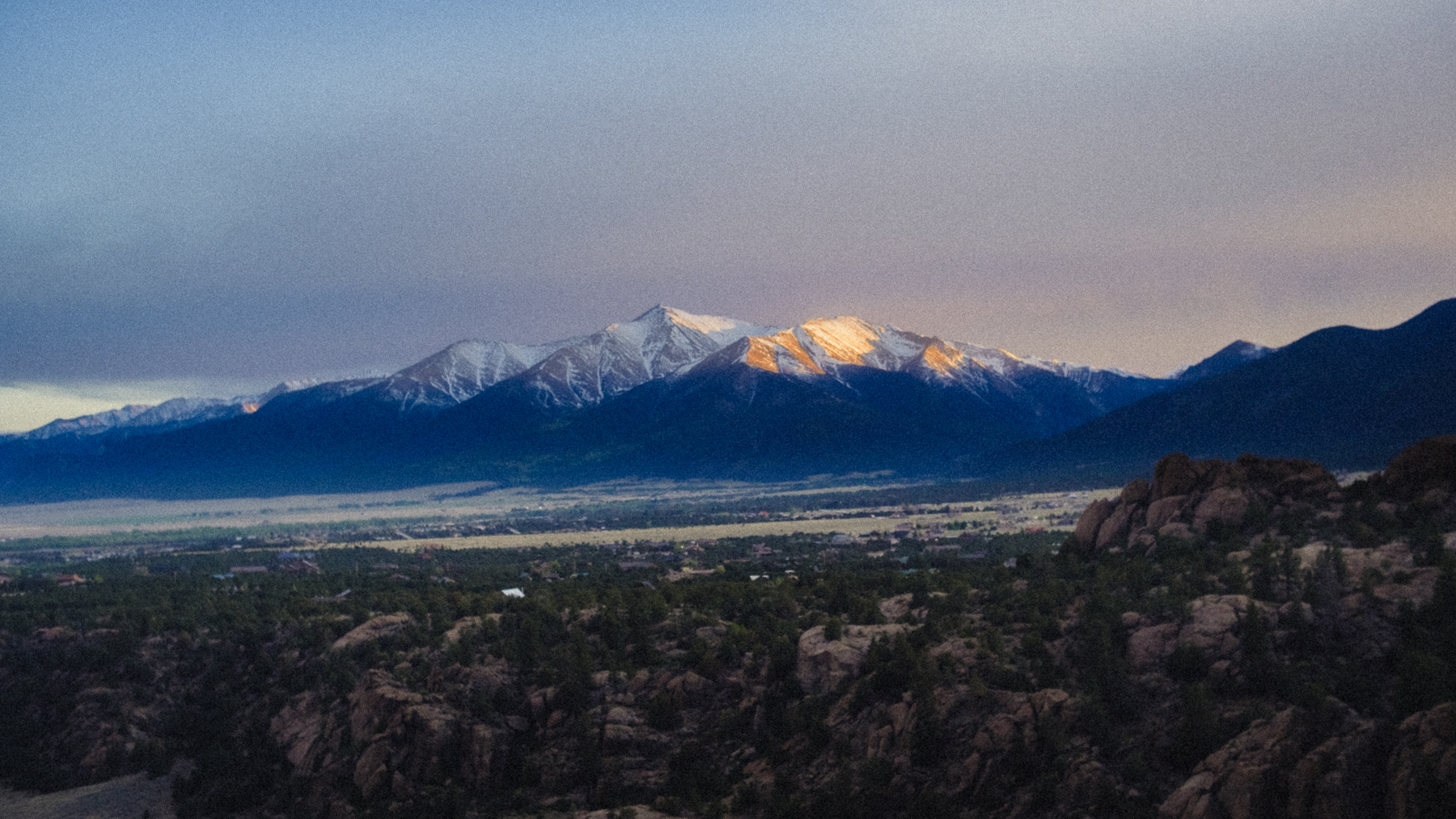 Golden sunset light illuminating a snow-capped mountain peak